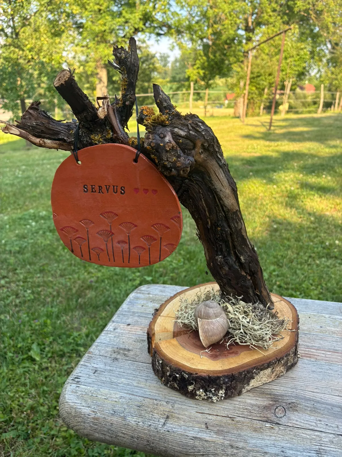 Deko-Weinstock mit Tonschild „Servus“ und kleinen roten Herzen
