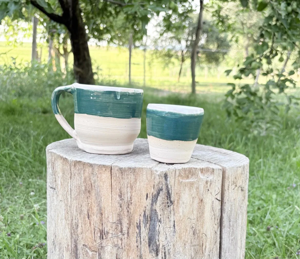 Handgetöpferte Tasse und Becher mit waldgrüner Glasur im Garten
