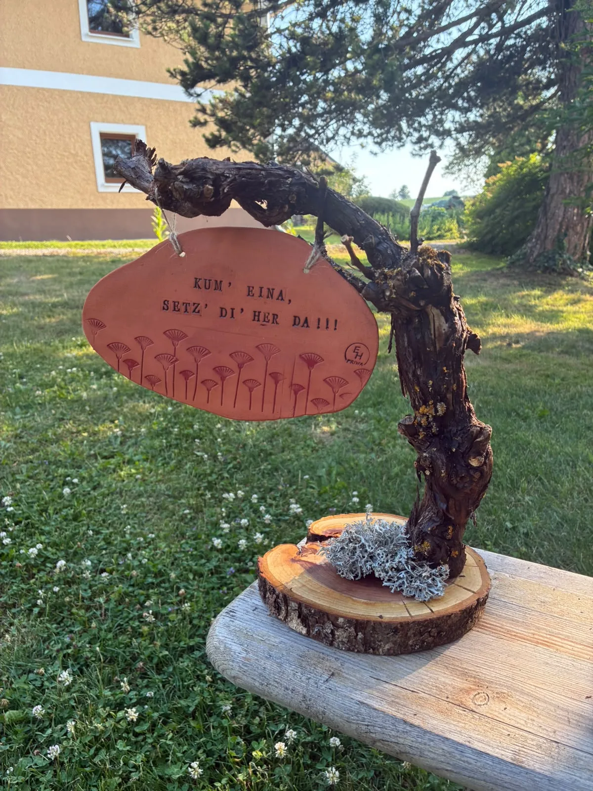 Deko-Weinstock mit hängendem Tonschild im Garten fotografiert